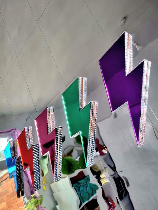 Coloured mirror lightning bolts, edged with silver glass disco tiles.
