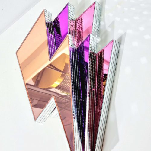 Handmade mirror lightning bolts in pink, purple and rose gold on a white background.