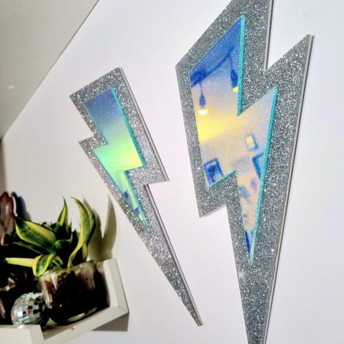SILVER GLITTER LIGHTNING BOLT WALL DECOR WITH IRIDESCENT FEATURE.