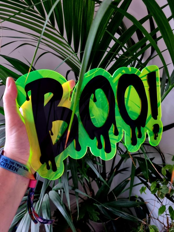 Neon green wall decor with the word Boo made in a dripping font.