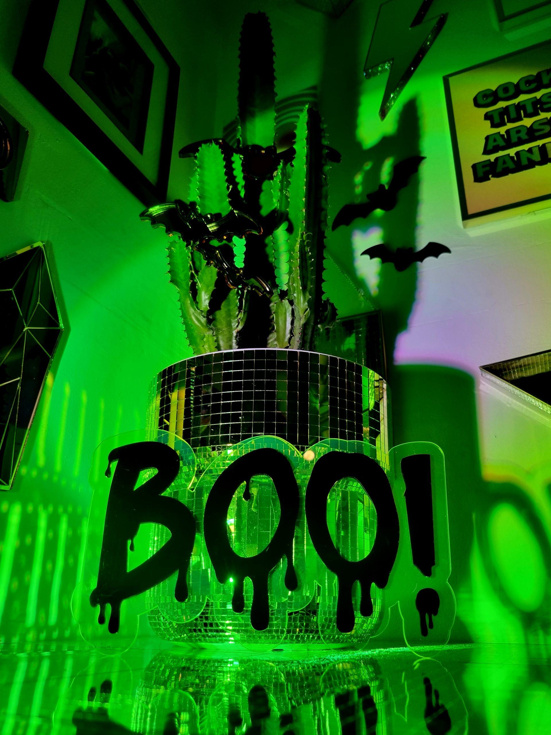 Neon green wall decor with the word Boo made in a dripping font.