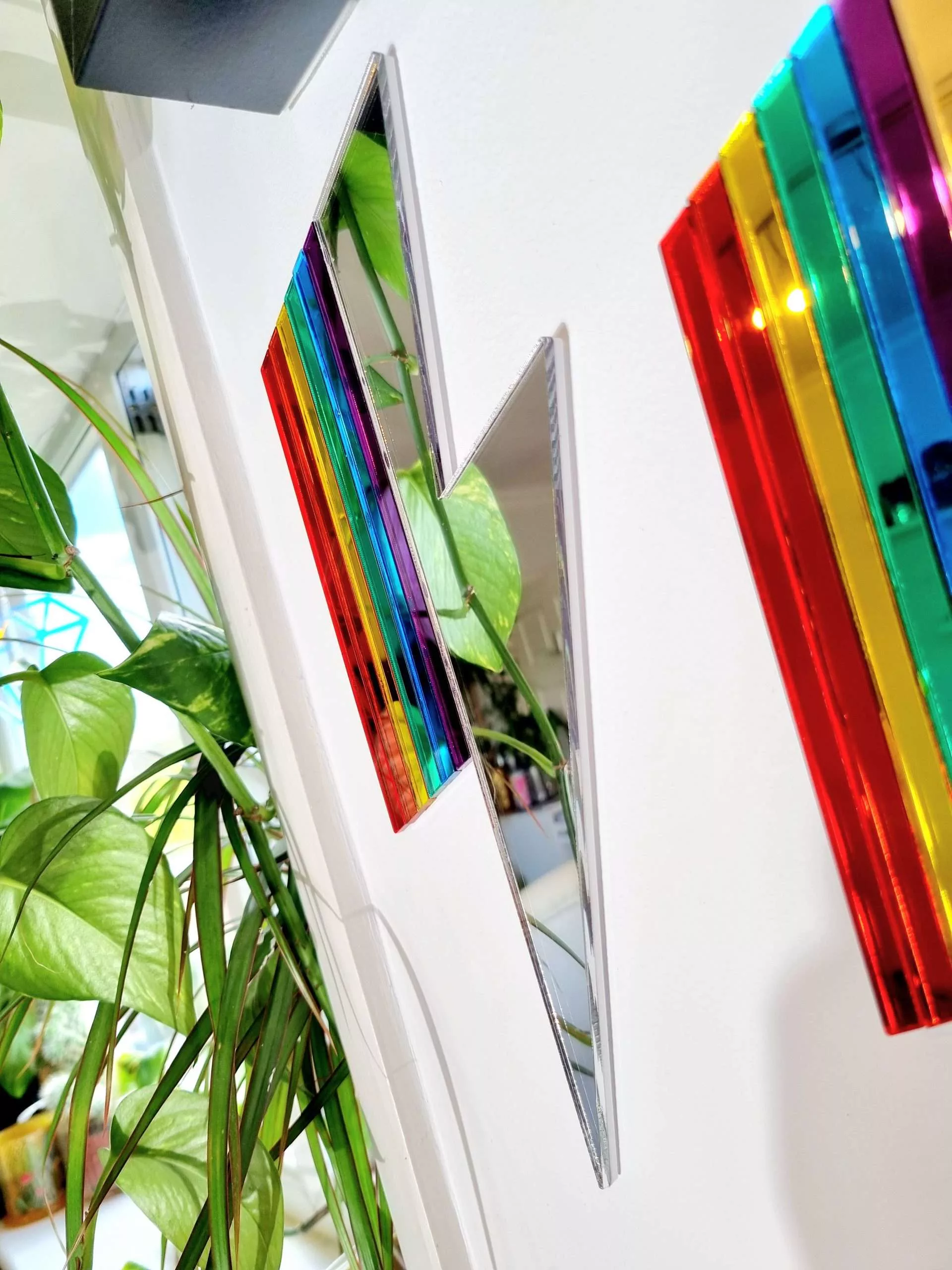 Mirrors in the shape of lightning bolts. They have pieces of gold and silver mirror, along with rainbow mirror pieces to create a spectrum effect.