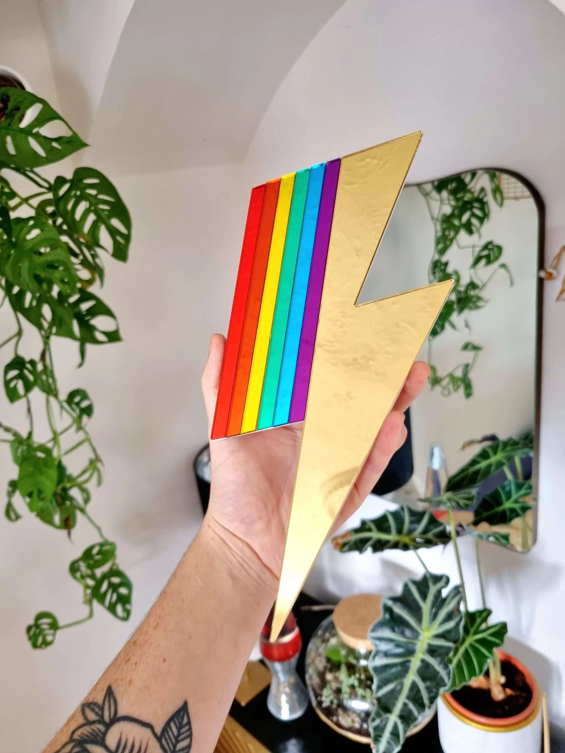 Mirrors in the shape of lightning bolts. They have pieces of gold and silver mirror, along with rainbow mirror pieces to create a spectrum effect.