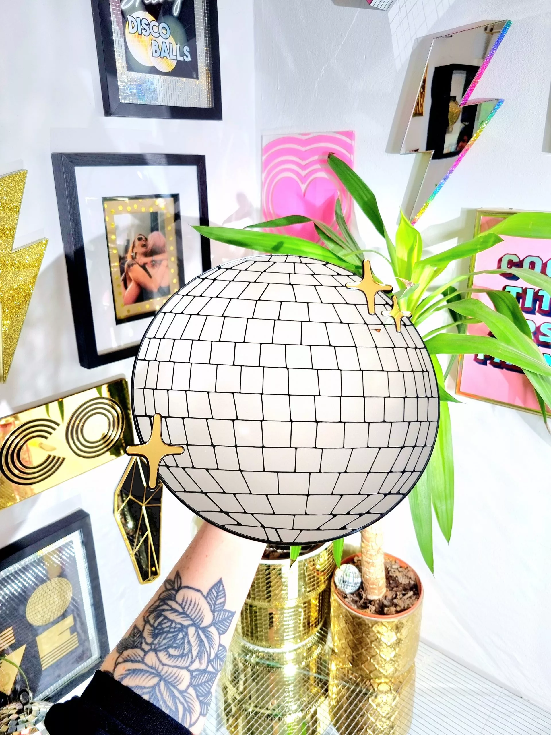 Handmade mirror in the shape and style of a disco ball. The round silver mirror is reverse engraved to show the details of the glitter ball. Finished with a black gloss backing and gold mirror twinkles.