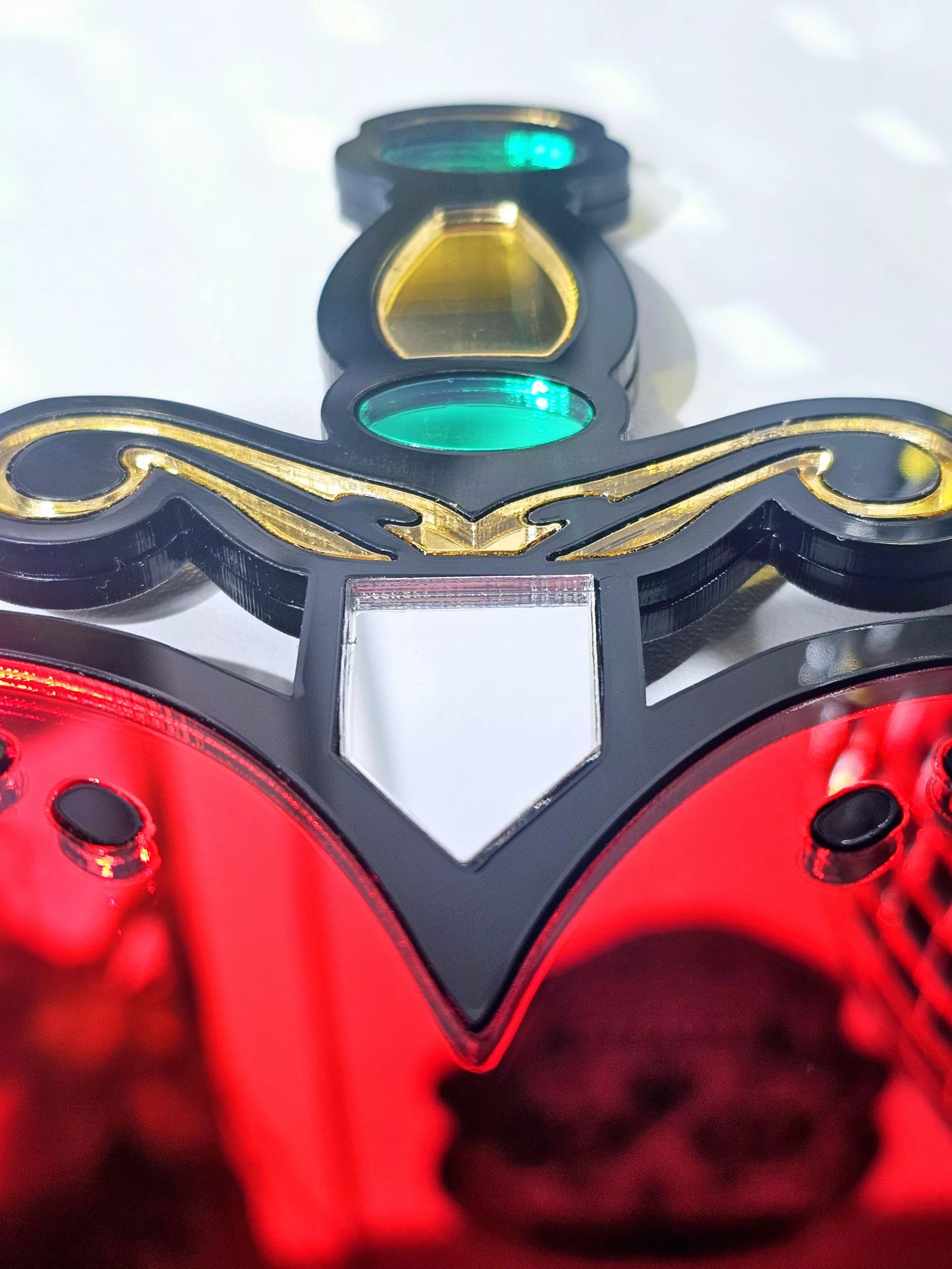A handmade mirror in the shape of a heart and dagger, in an old school tattoo style. The heart is red with a black outline and orgate dagger design.