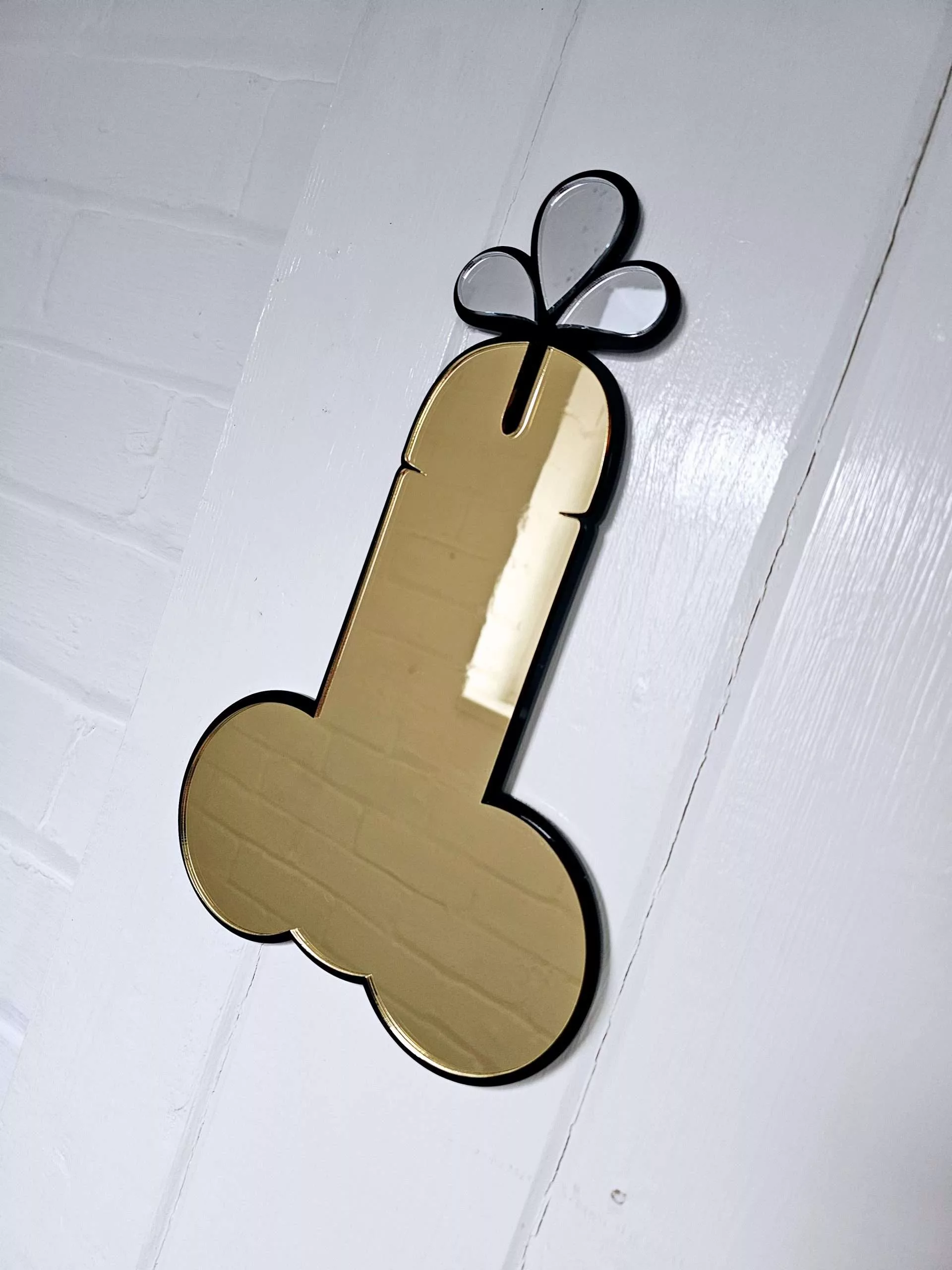 A handmade mirror in the shape of a penis.