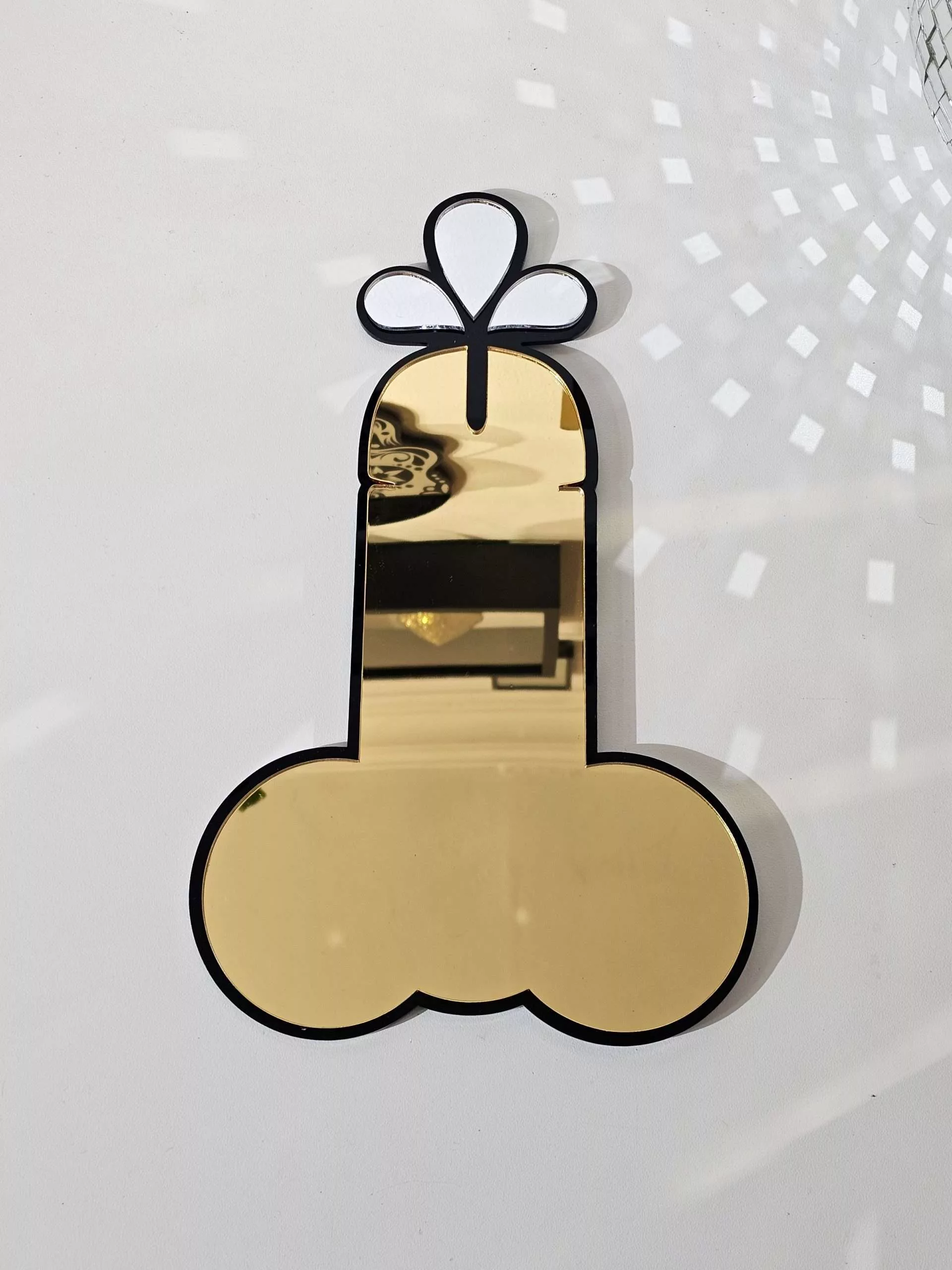 A handmade mirror in the shape of a penis.