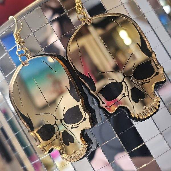 Earrings in the shape of a skull. The skull is made from shiny mirror with black details.