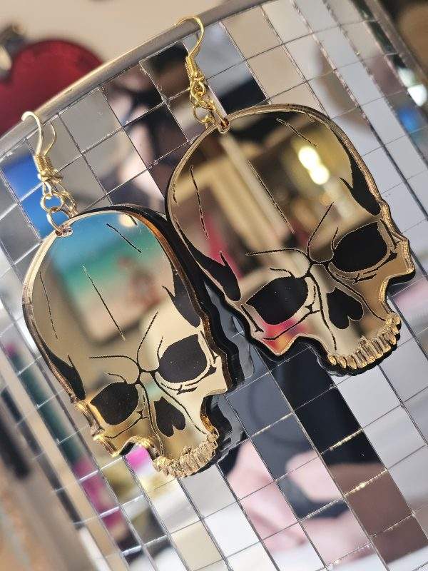 Earrings in the shape of a skull. The skull is made from shiny mirror with black details.
