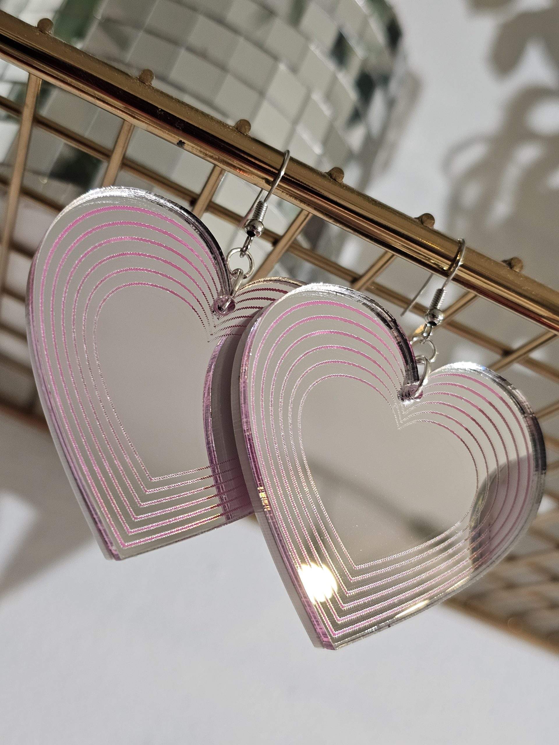 Heart shapped earrings made with silver mirror and candy pink details.