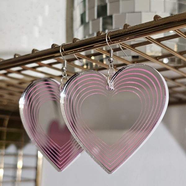 Heart shapped earrings made with silver mirror and candy pink details.