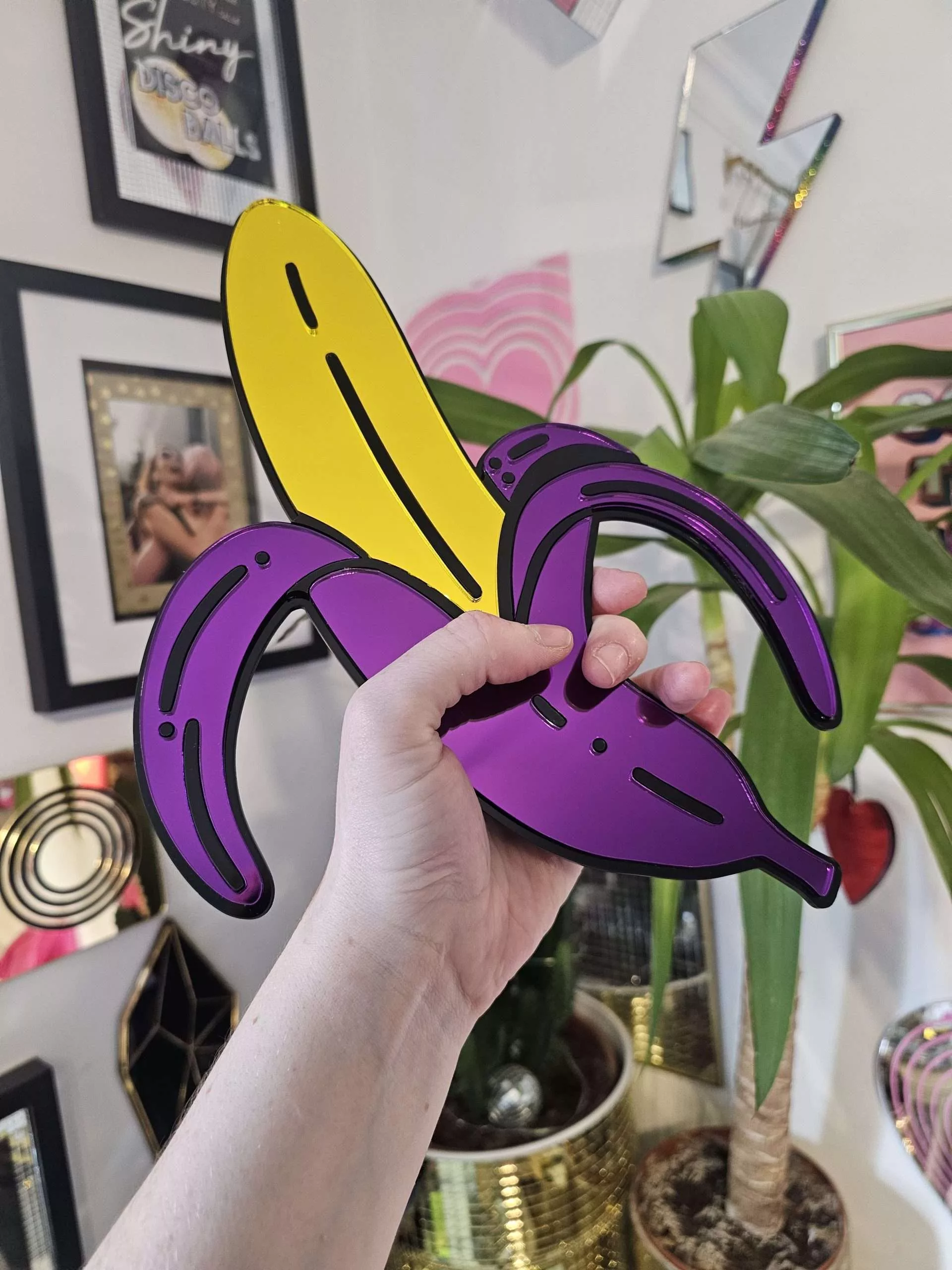 A handmade mirror in the shape of a banana.