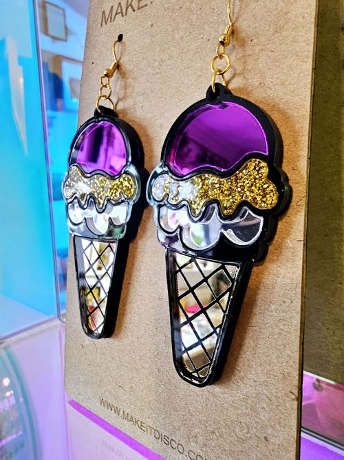 Handmade earrings in the shape of an ice cream. The earrings have a black outline, filled with mirror and gltter acrylic pieces.