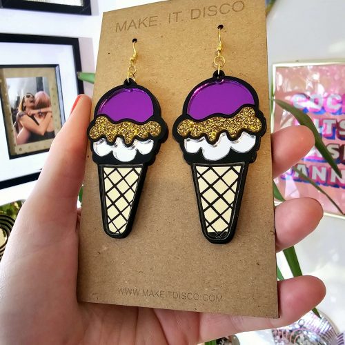 Handmade earrings in the shape of an ice cream. The earrings have a black outline, filled with mirror and gltter acrylic pieces.