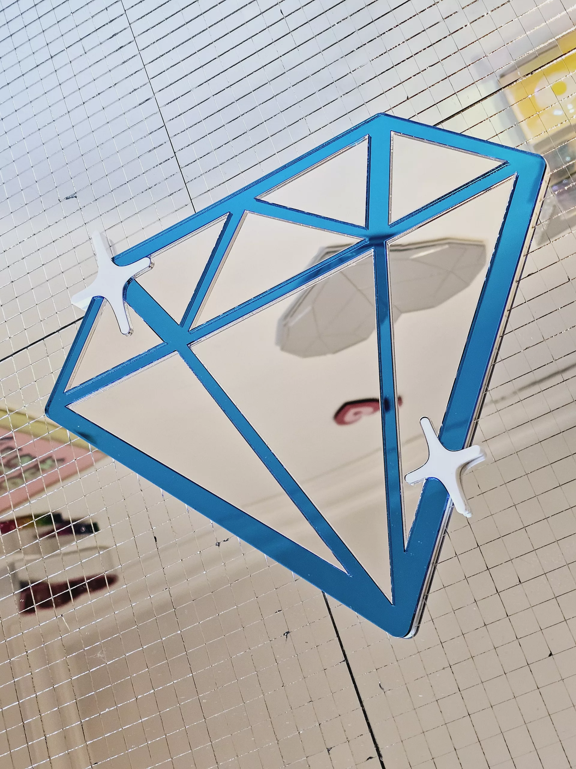 A handmade mirror in the shape of a diamond,