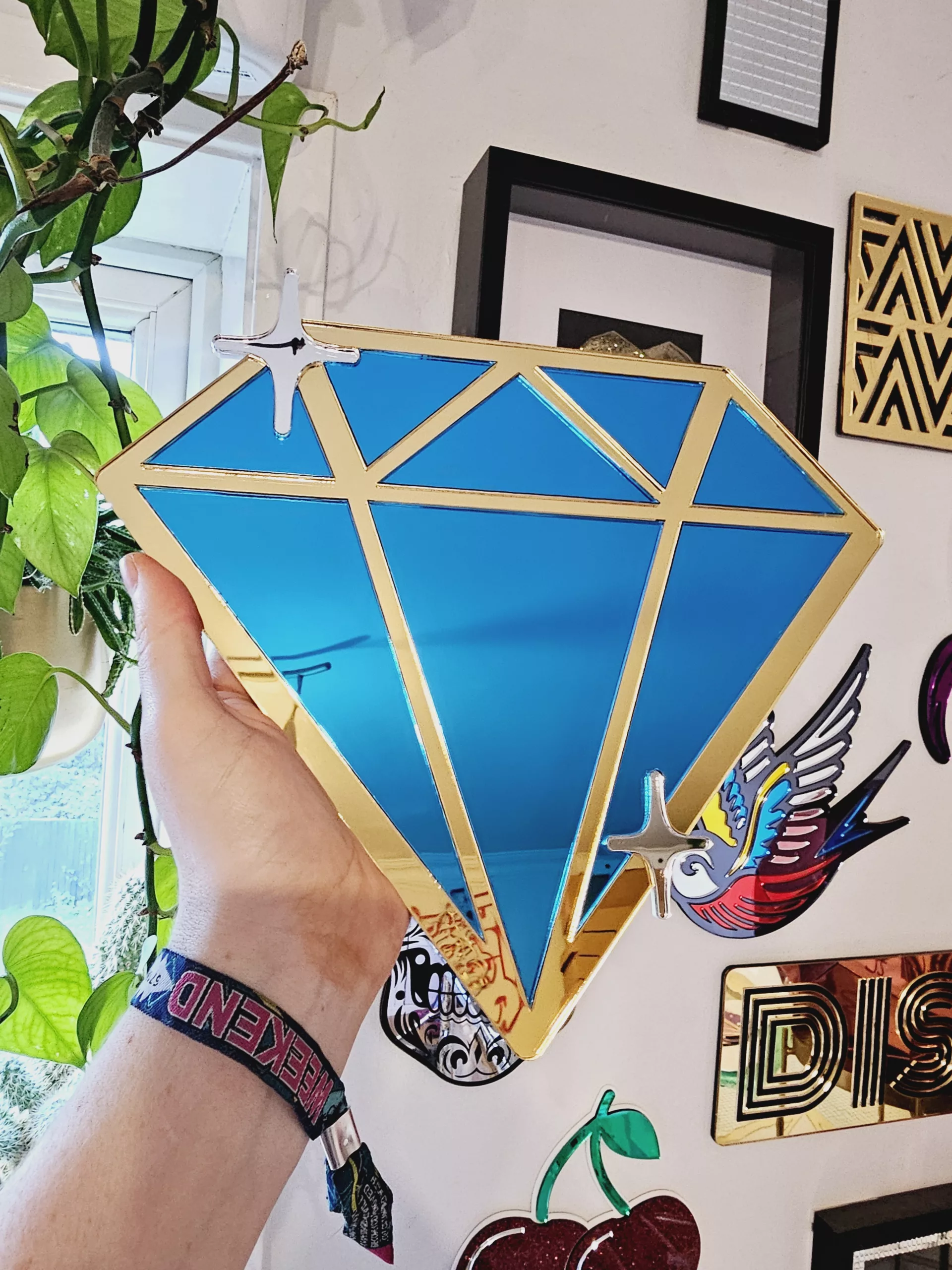 A handmade mirror in the shape of a diamond,