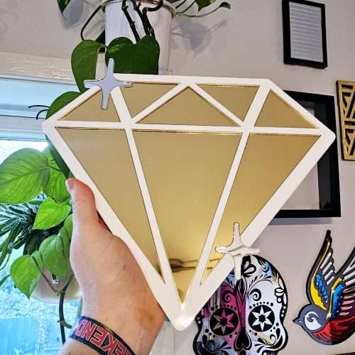 A handmade mirror in the shape of a diamond,