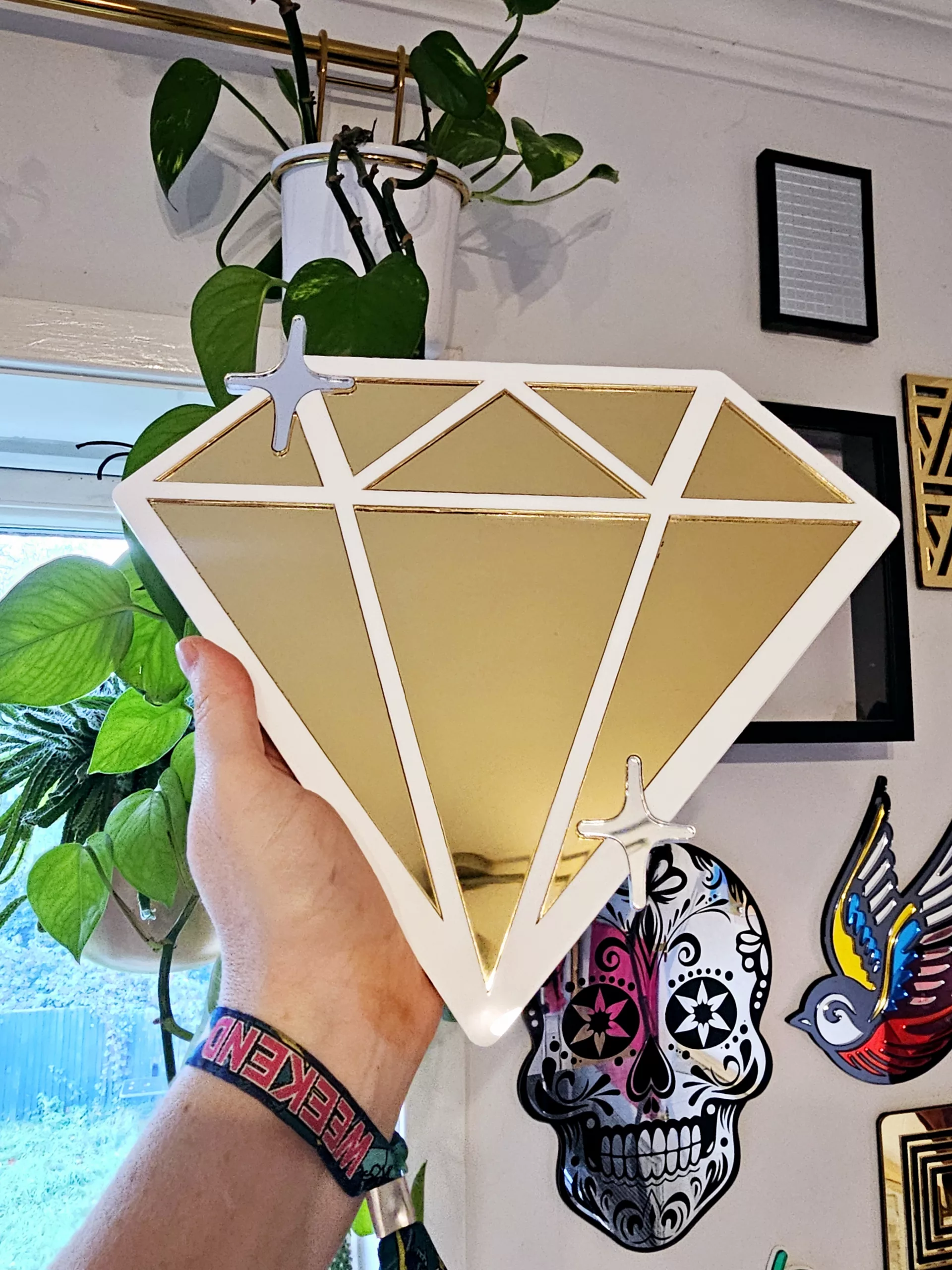 A handmade mirror in the shape of a diamond,