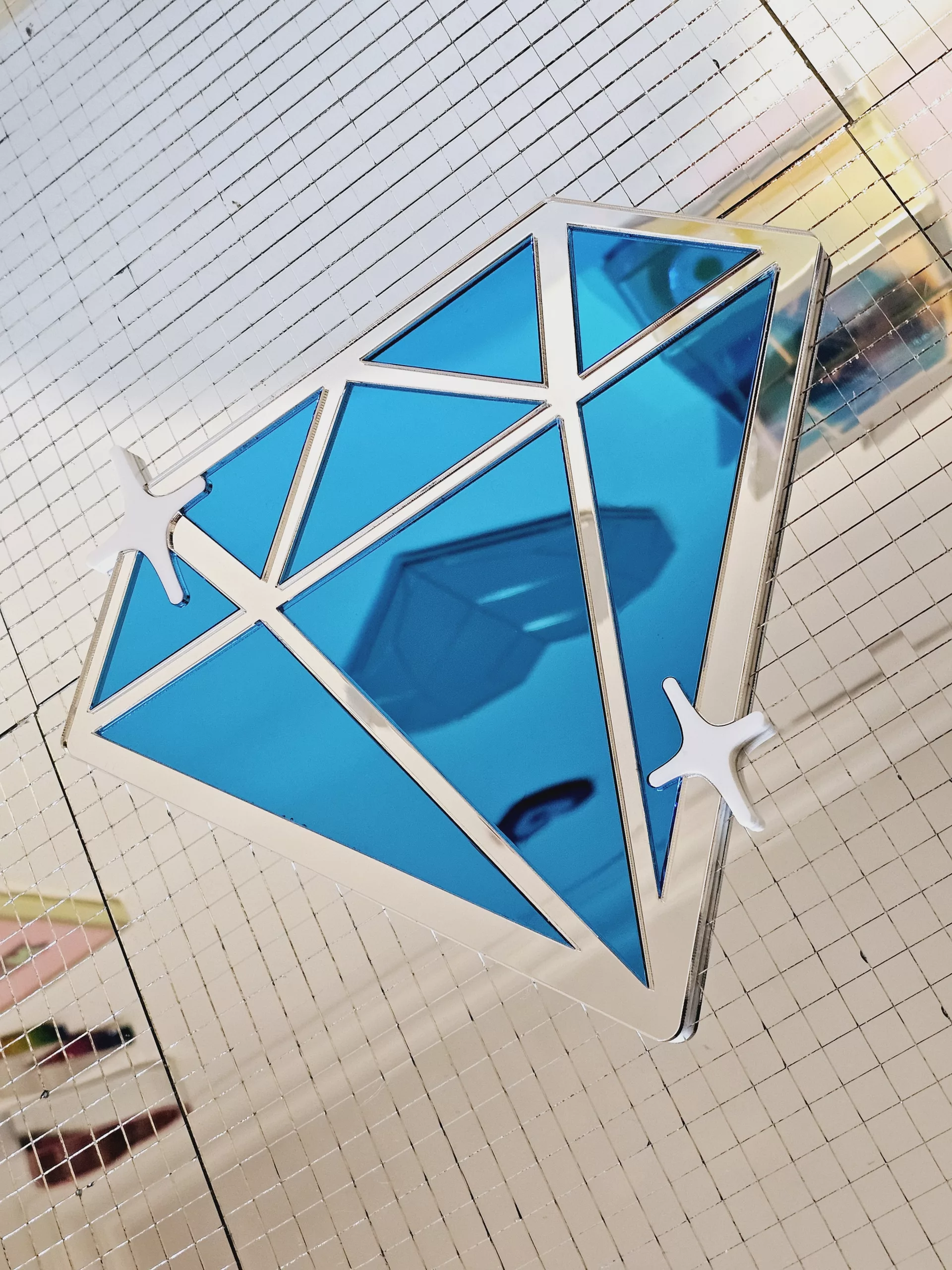 A handmade mirror in the shape of a diamond,