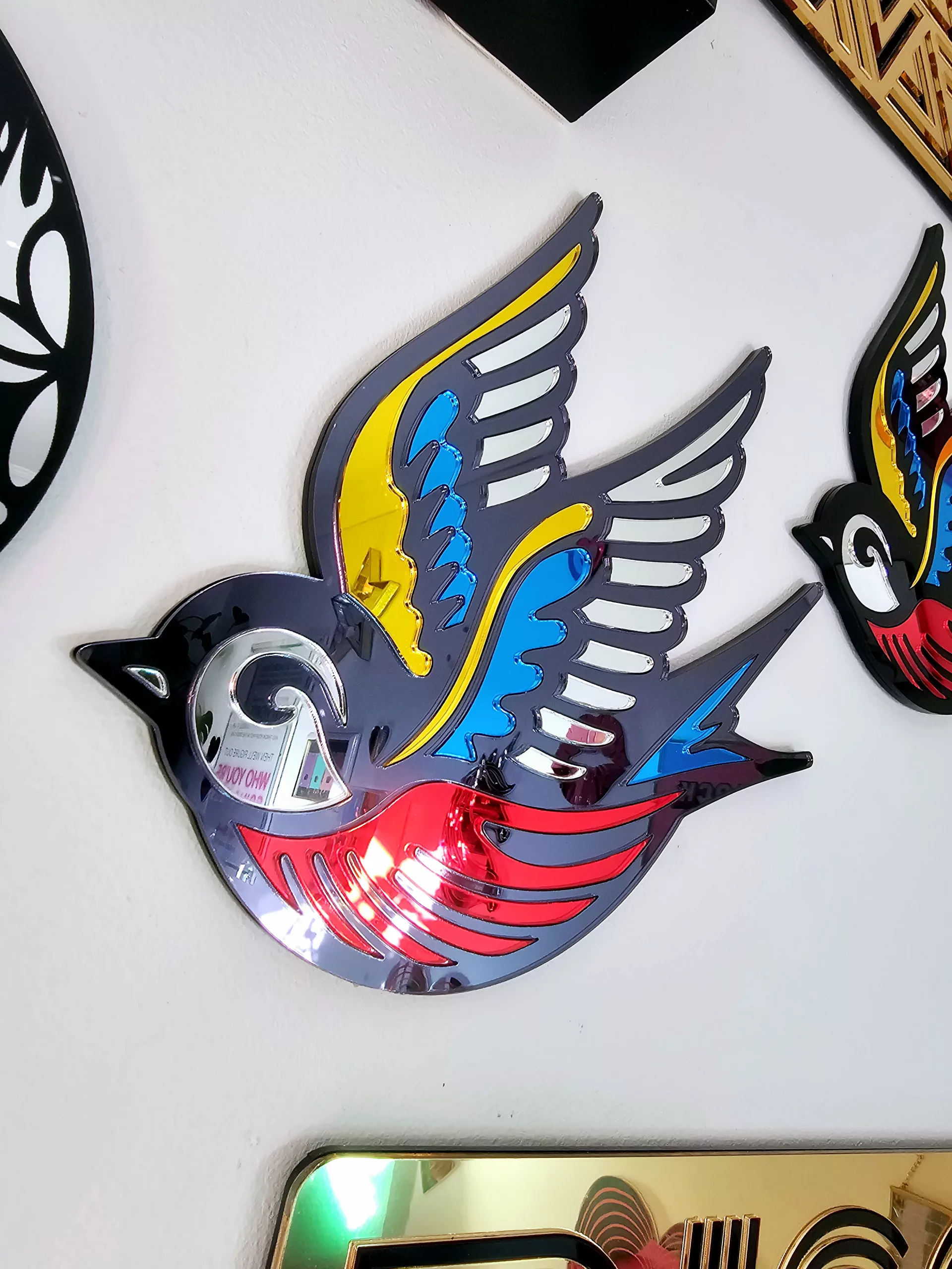 A mirror in the shape of a swallow, made in an old school tattoo style.