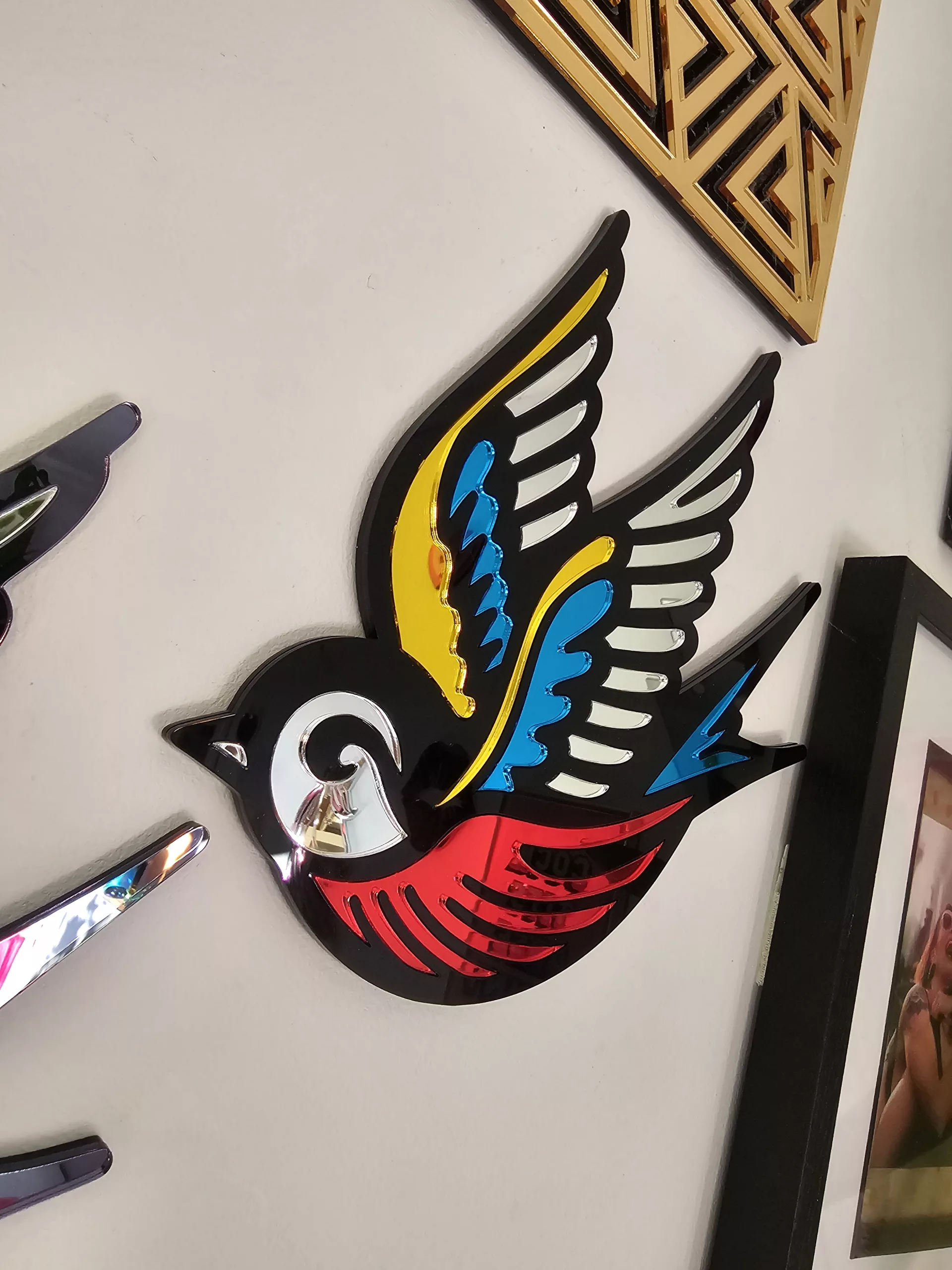 A mirror in the shape of a swallow, made in an old school tattoo style.