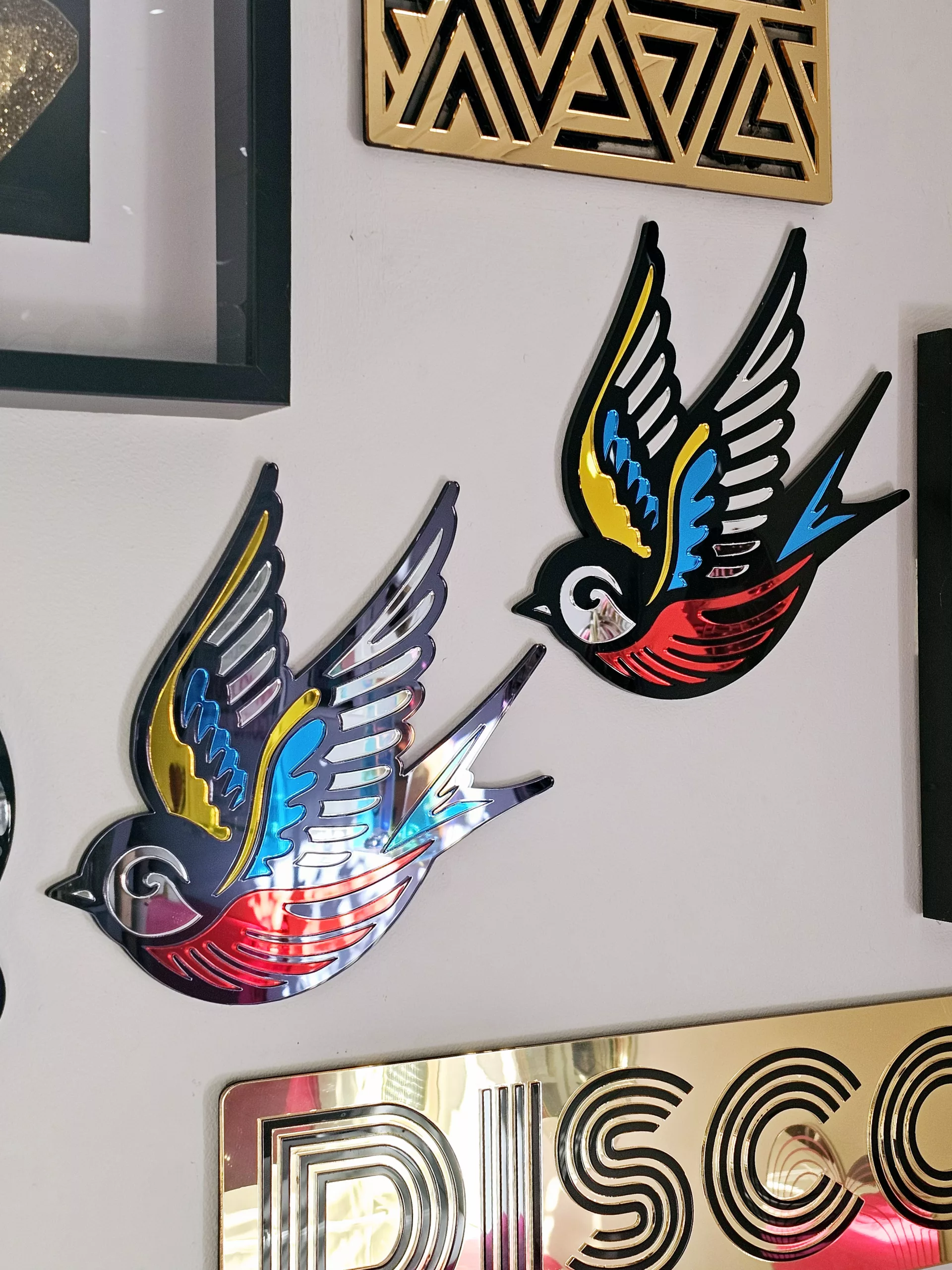 A mirror in the shape of a swallow, made in an old school tattoo style.