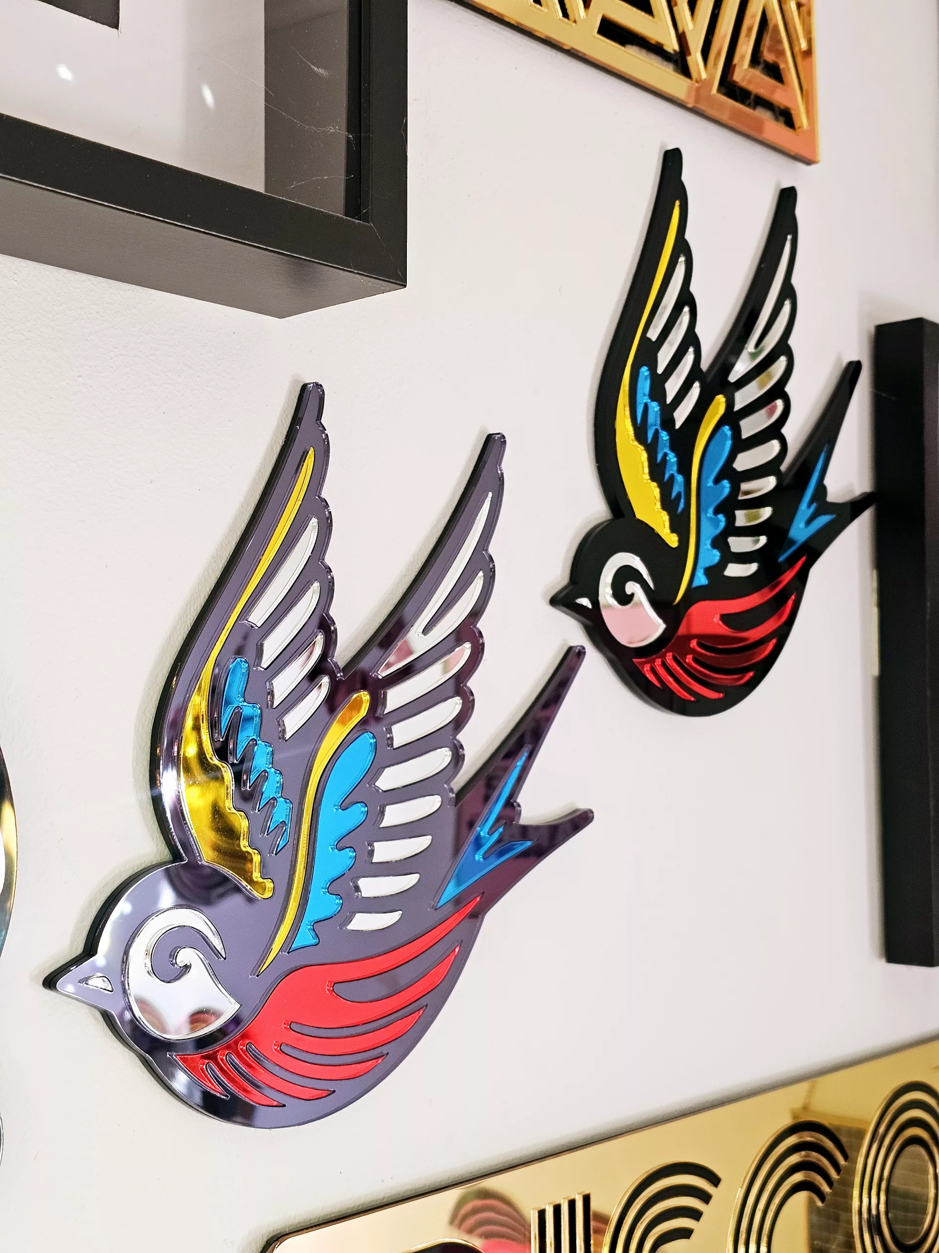 A mirror in the shape of a swallow, made in an old school tattoo style.