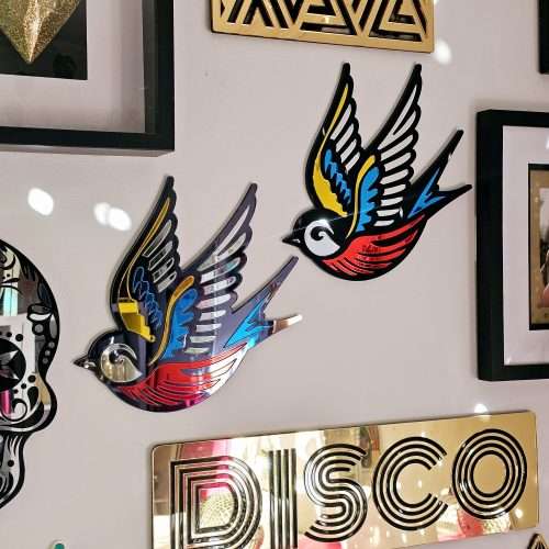 A mirror in the shape of a swallow, made in an old school tattoo style.