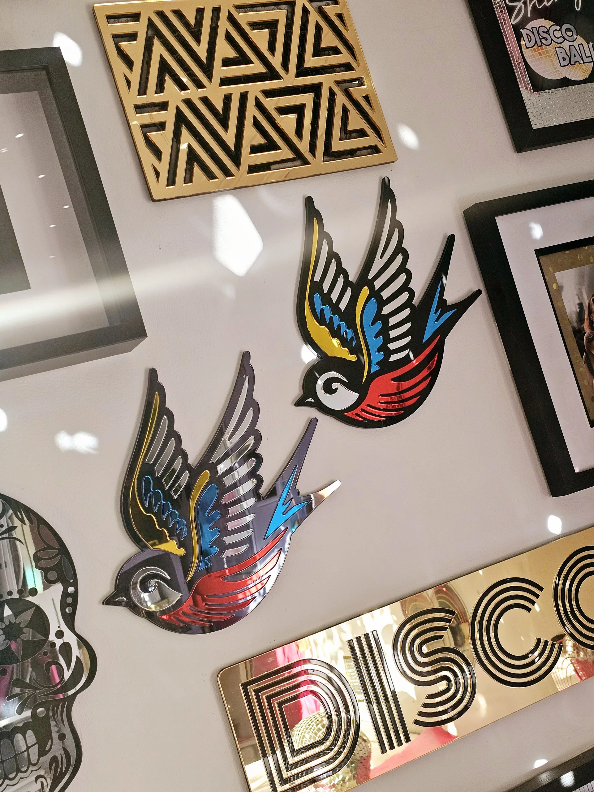 A mirror in the shape of a swallow, made in an old school tattoo style.