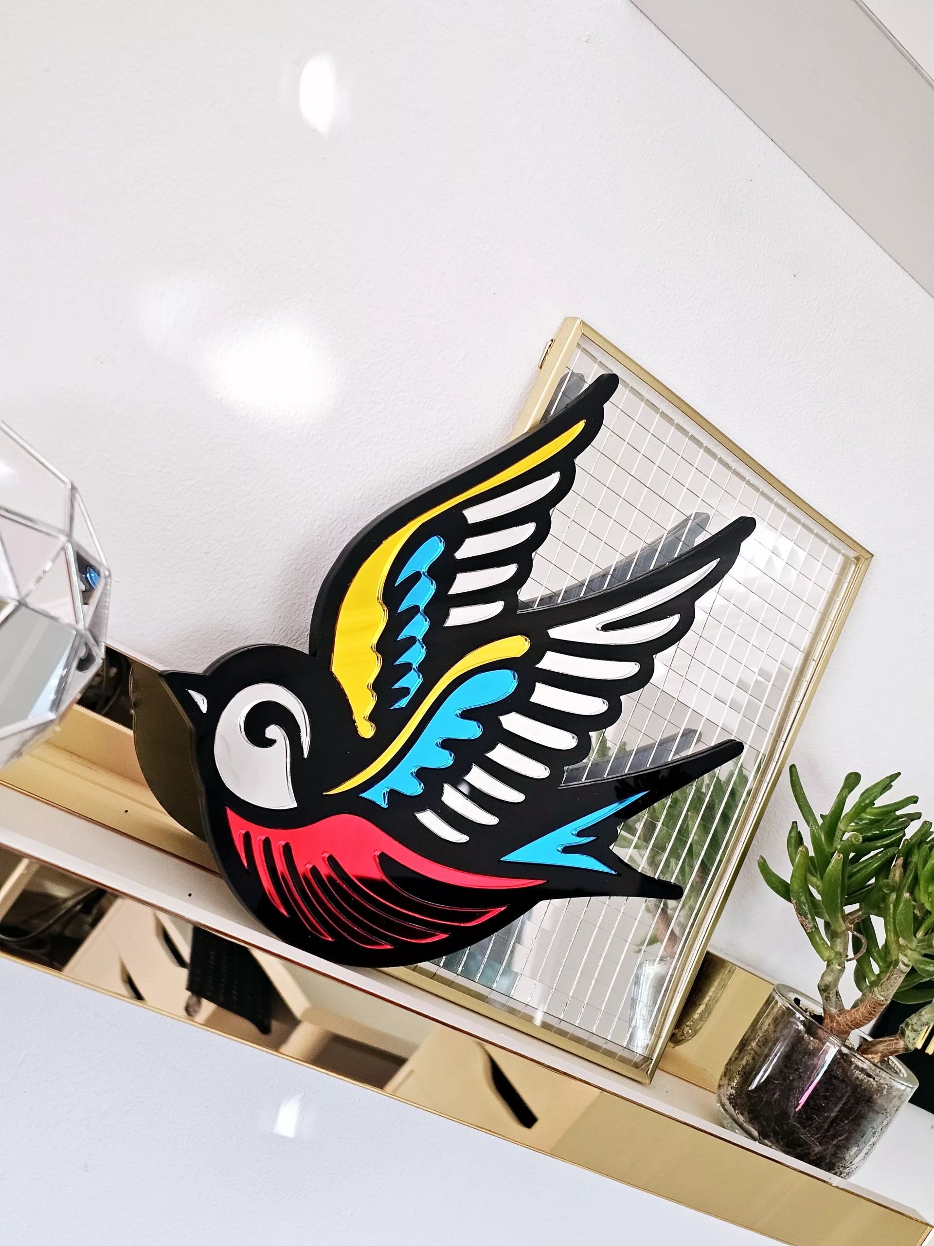 A mirror in the shape of a swallow, made in an old school tattoo style.