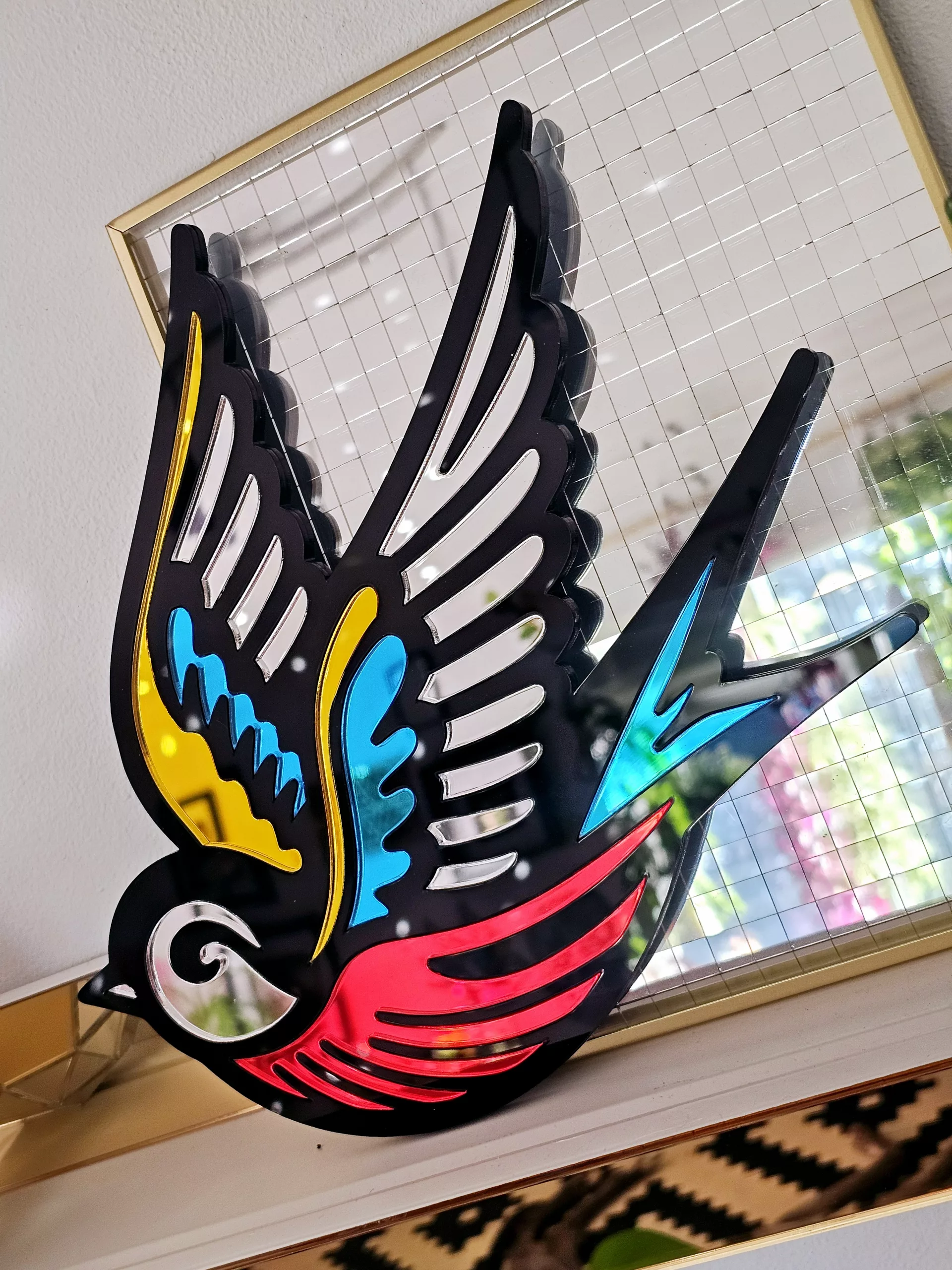 A mirror in the shape of a swallow, made in an old school tattoo style.