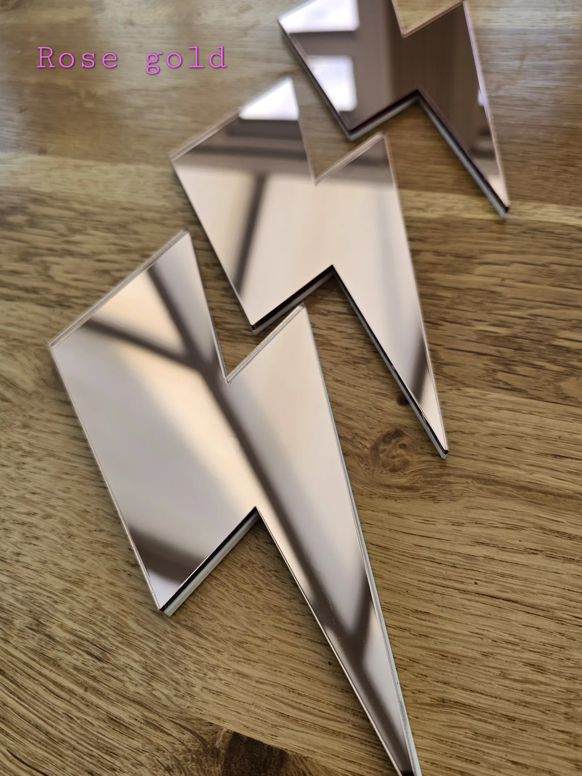 A set of 3 mirrors in the shape of a lightning bolt, in a variety of colours.