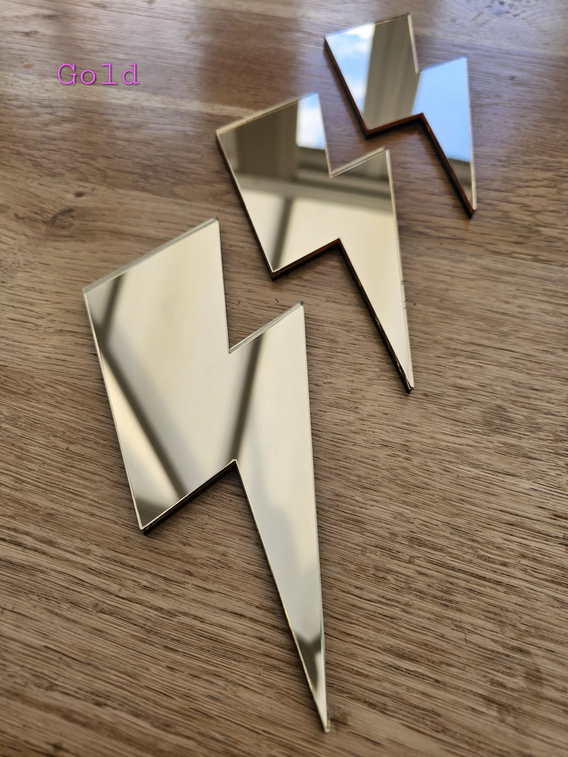 A set of 3 mirrors in the shape of a lightning bolt, in a variety of colours.