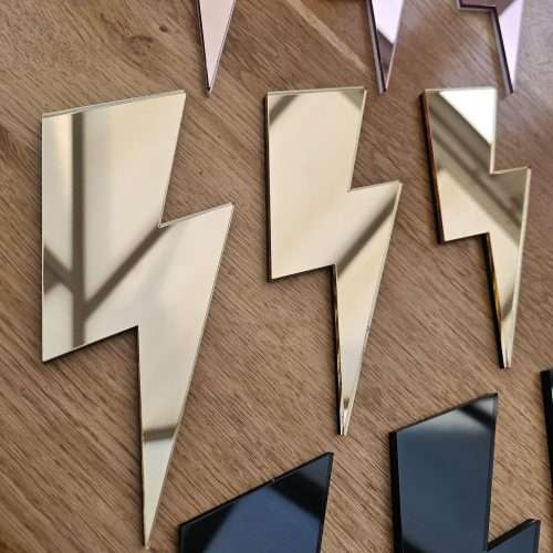 A set of 3 mirrors in the shape of a lightning bolt, in a variety of colours.