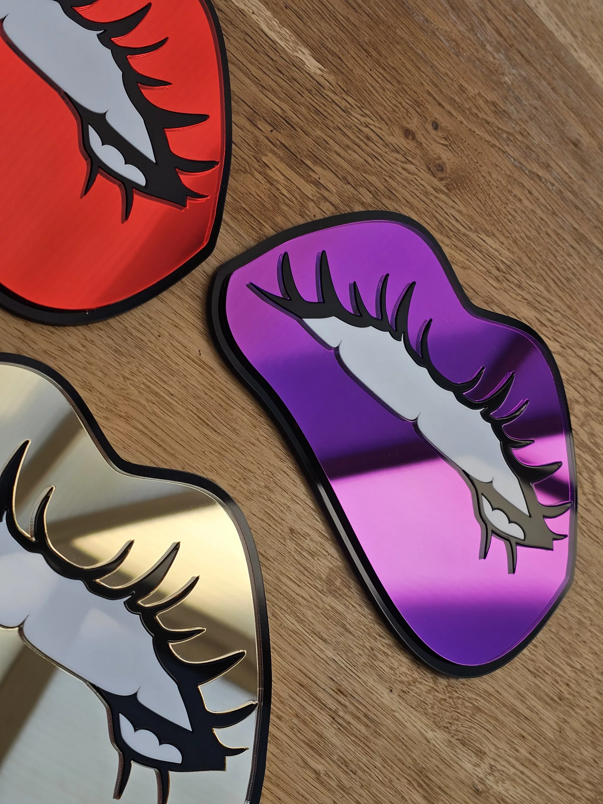 A handmade mirror in the shape of lips with the bottom lip being bitten. Made with mirror lips and glossy white teeth.