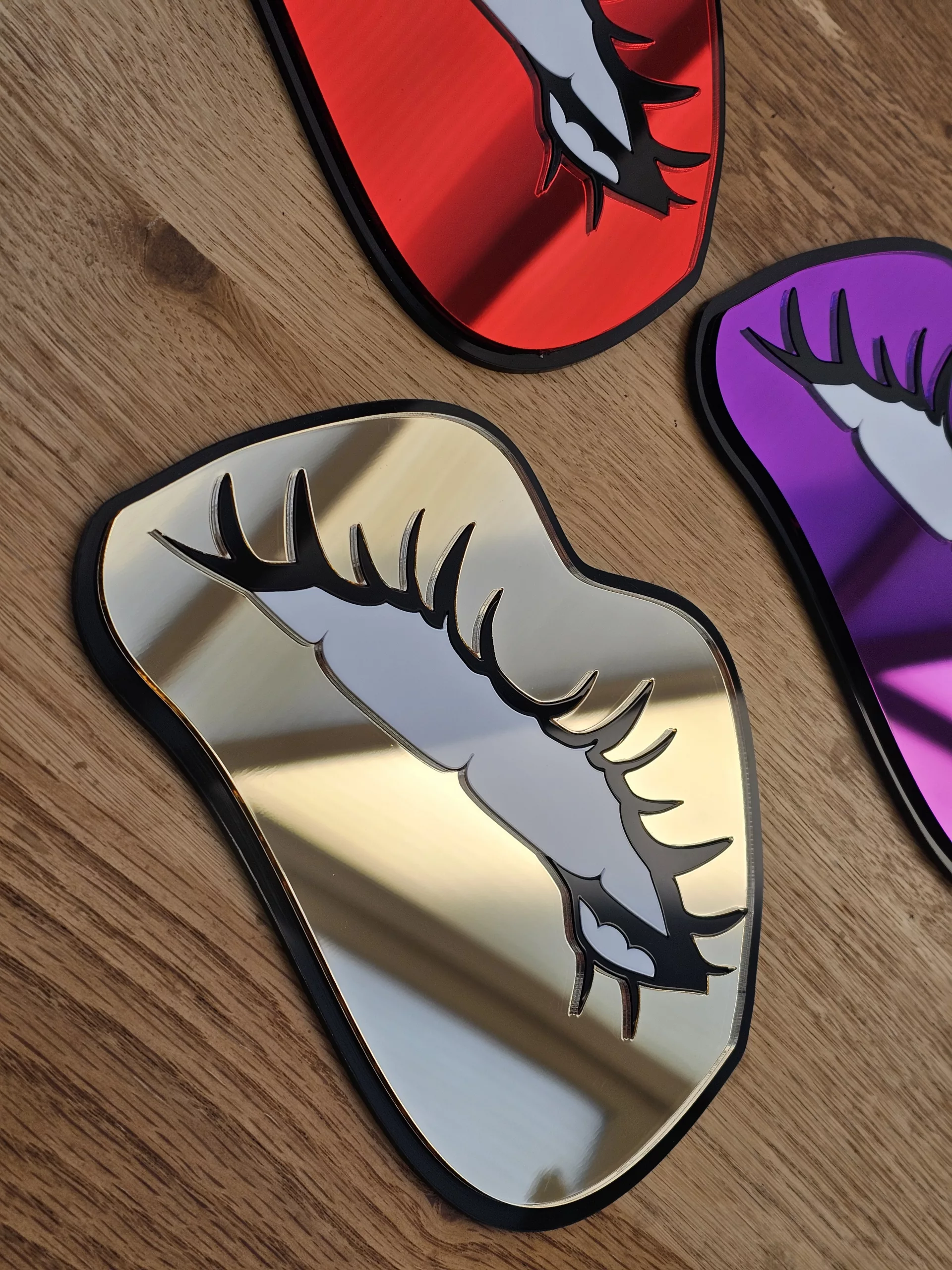 A handmade mirror in the shape of lips with the bottom lip being bitten. Made with mirror lips and glossy white teeth.