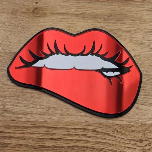A handmade mirror in the shape of lips with the bottom lip being bitten. Made with mirror lips and glossy white teeth.