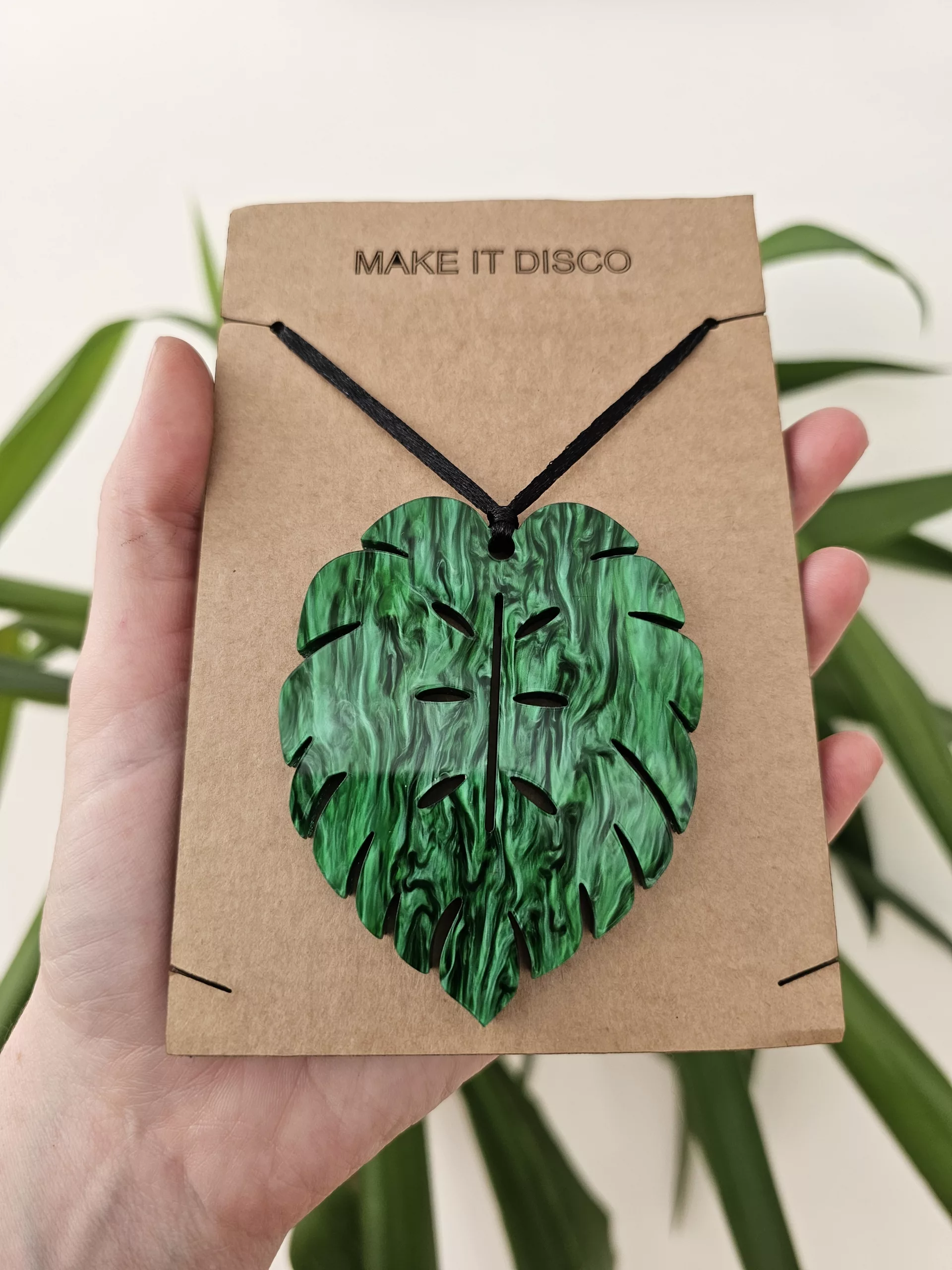 A plant charm or Christmas tree decoration in the shape of a Monstera Leaf.