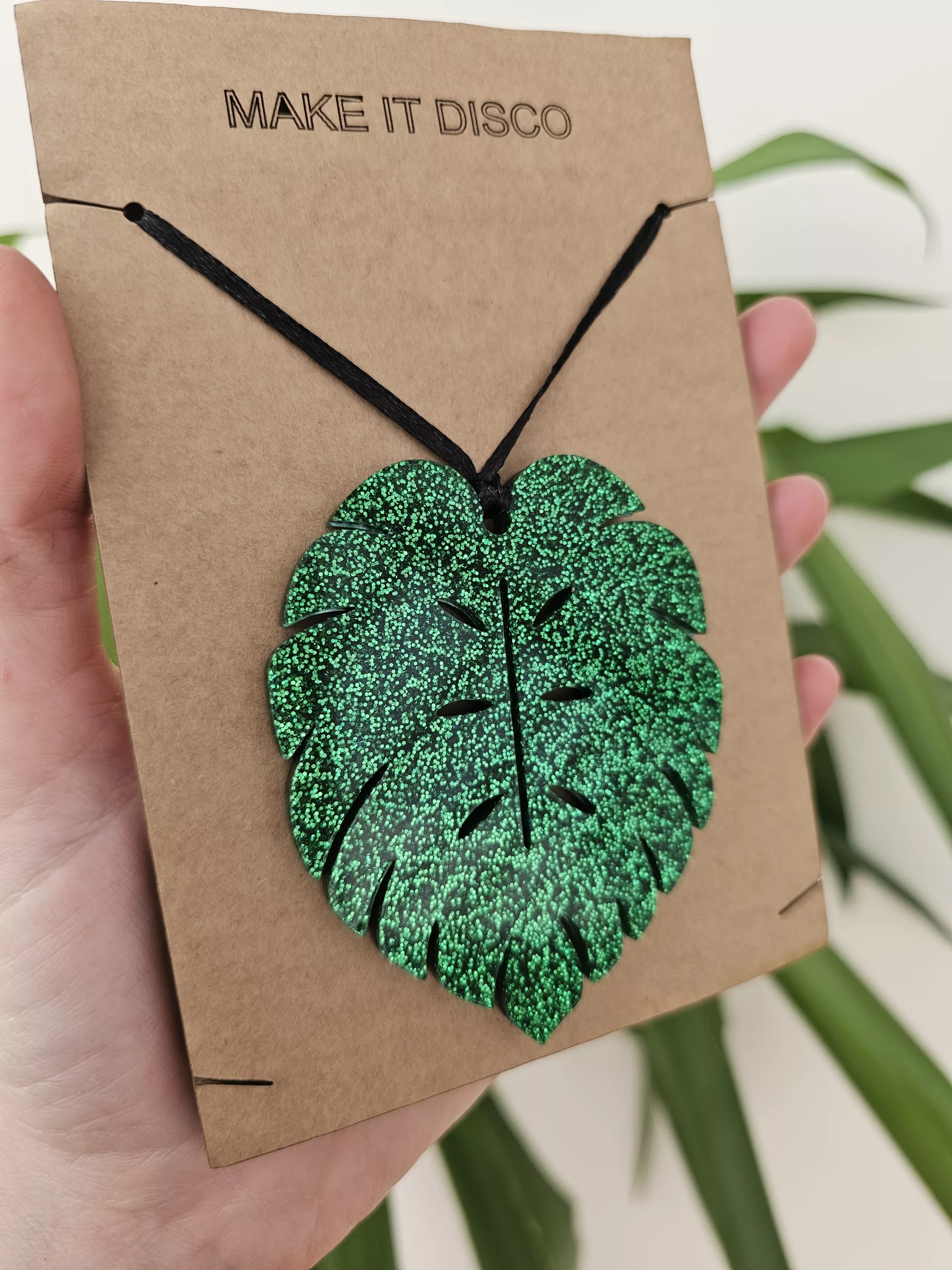A plant charm or Christmas tree decoration in the shape of a Monstera Leaf.