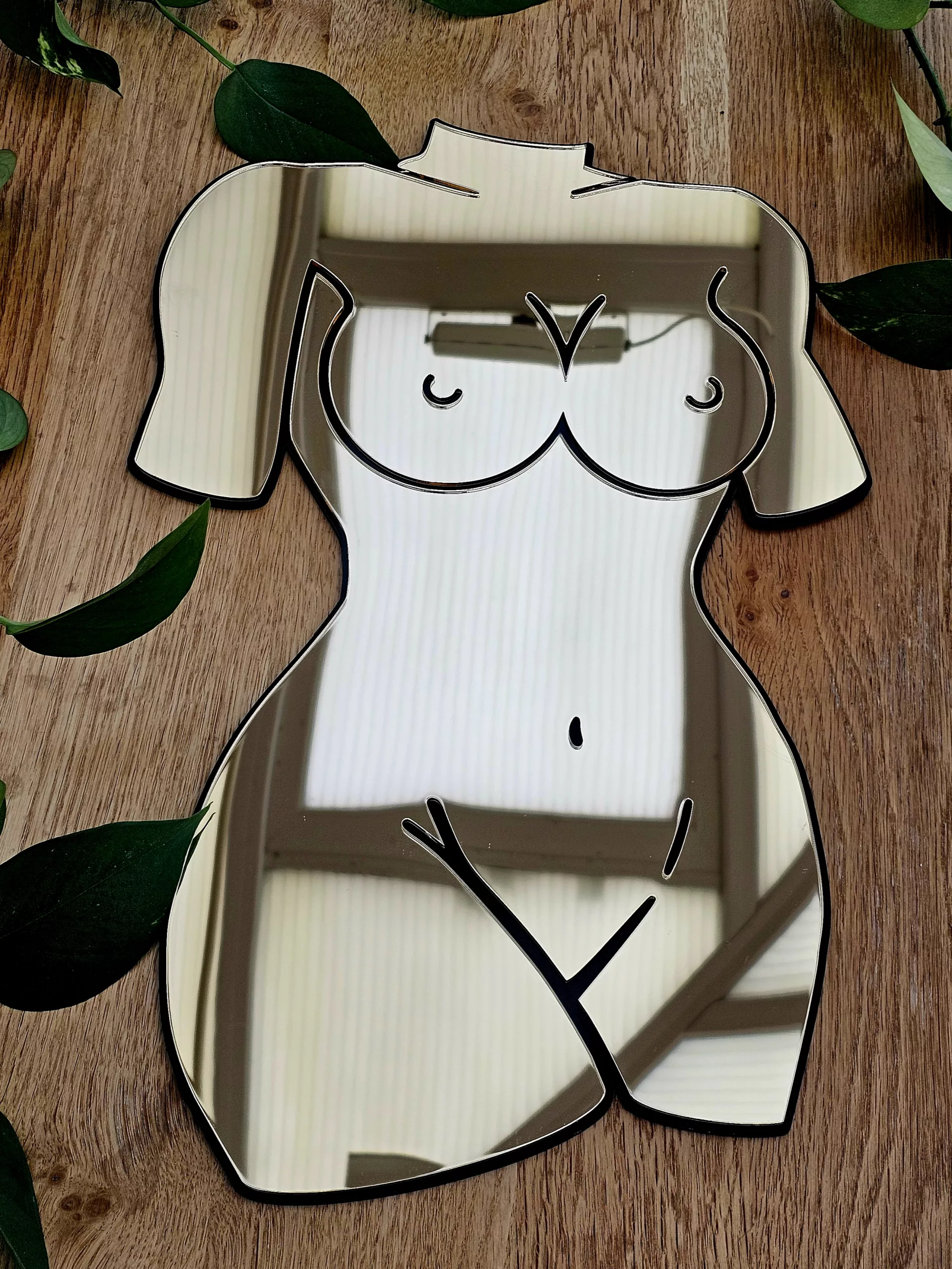 A mirror in the shape of a female silhouette.