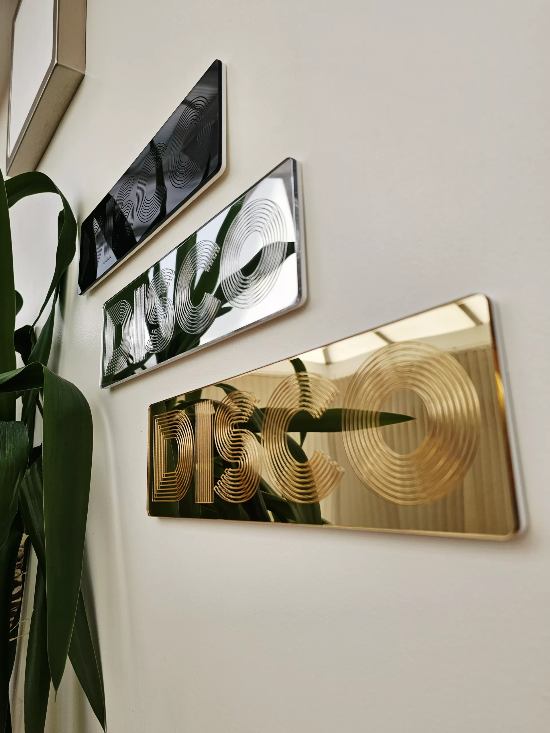 A picture of a disco wall art sign, made with mirror and retro font.