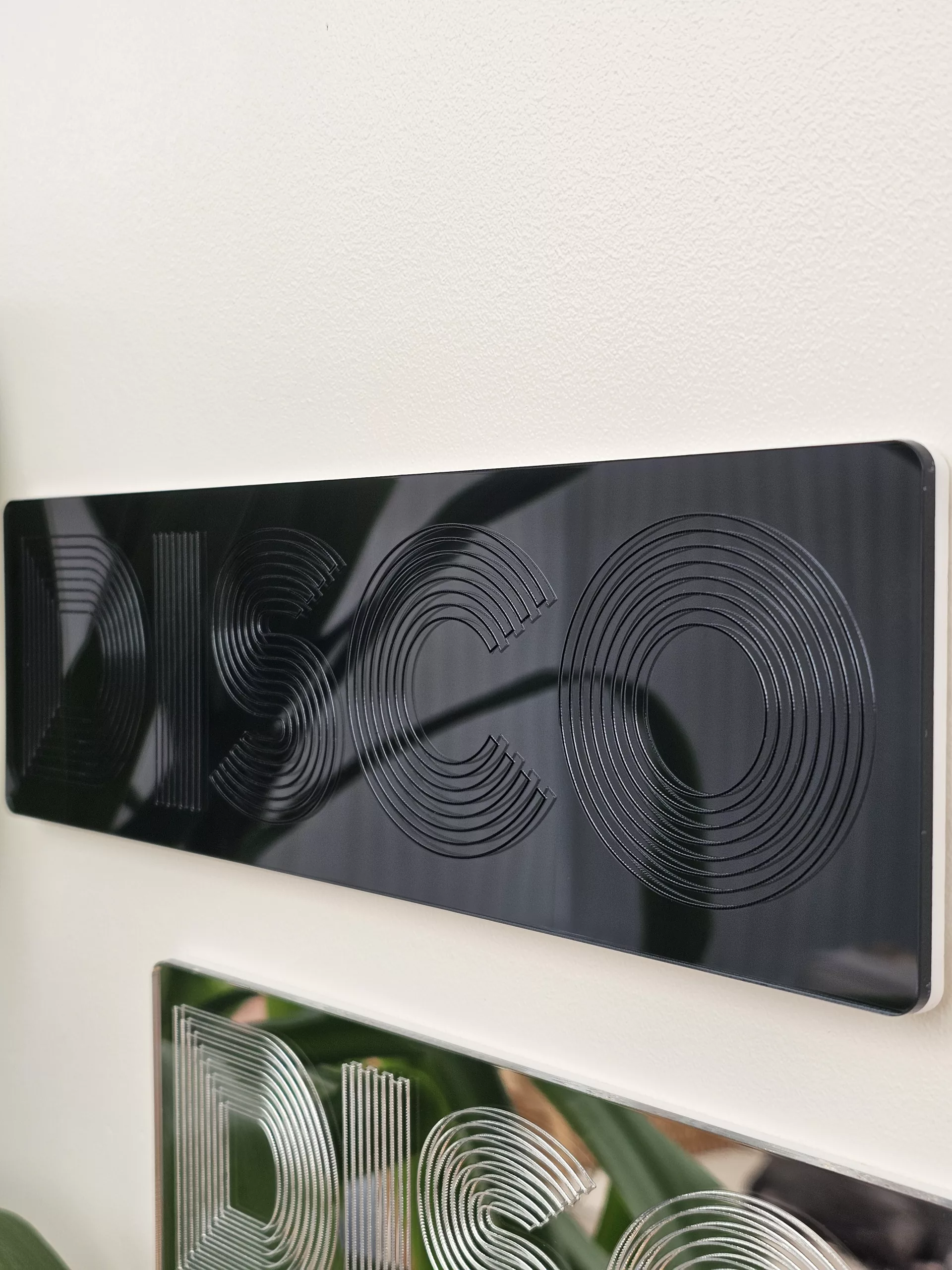 A picture of a disco wall art sign, made with mirror and retro font.