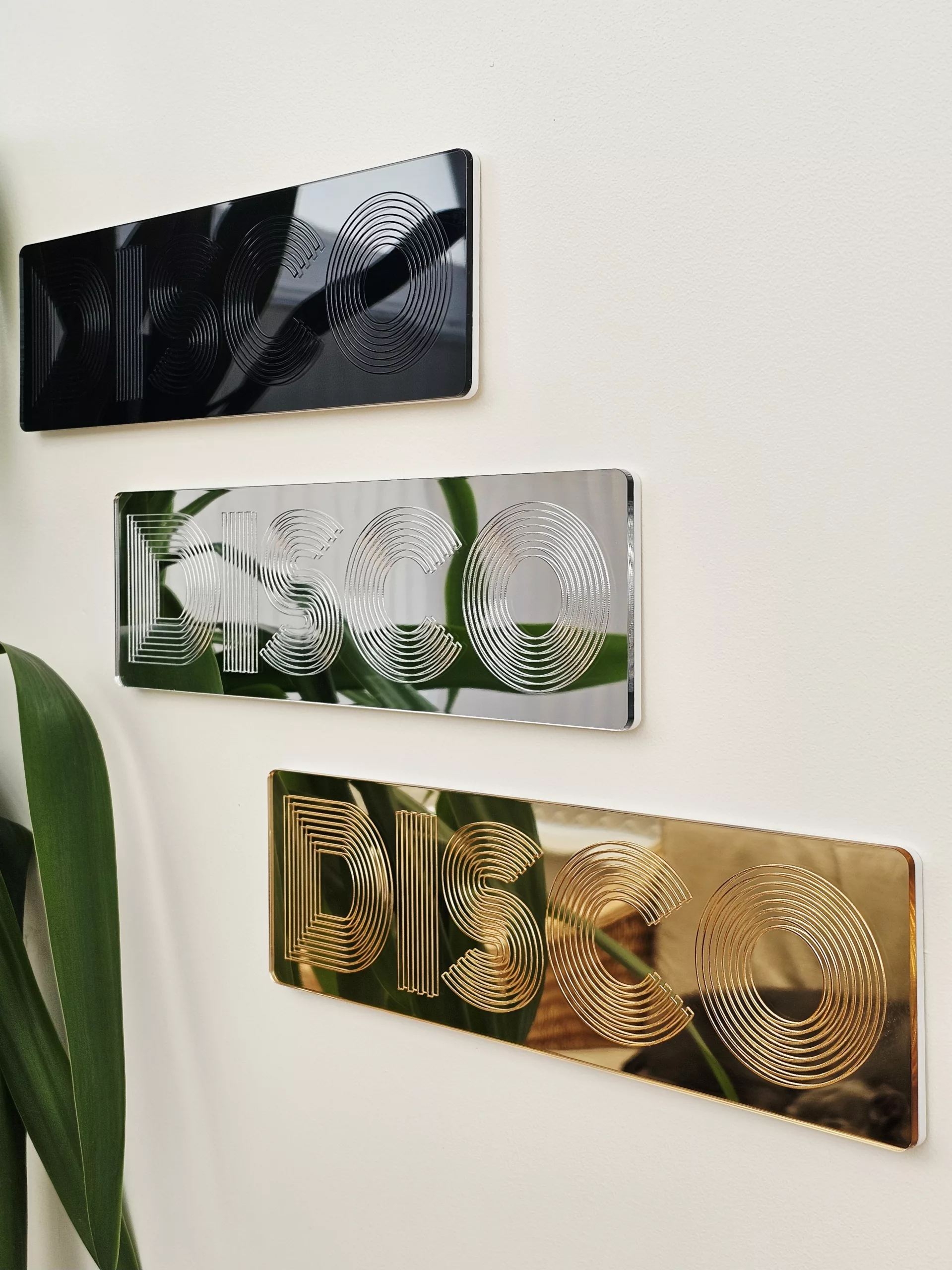 A picture of a disco wall art sign, made with mirror and retro font.