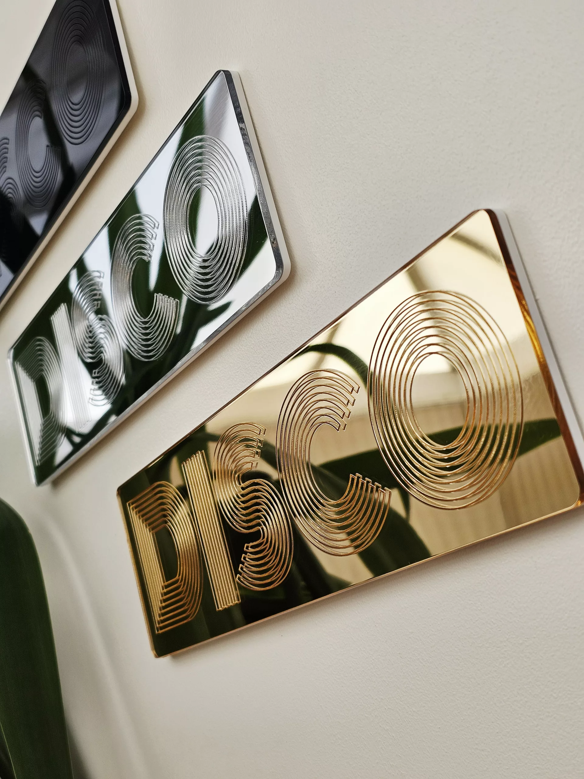 A picture of a disco wall art sign, made with mirror and retro font.