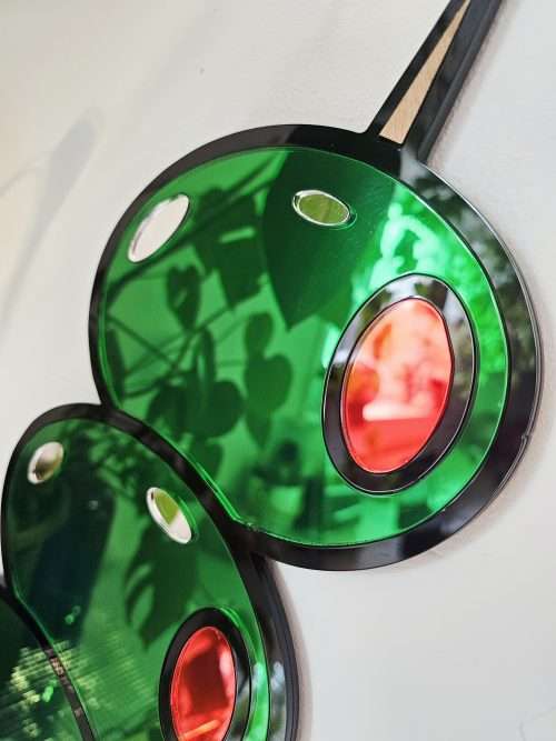Mirrored wall art in the shape of olives on a cocktail stick.