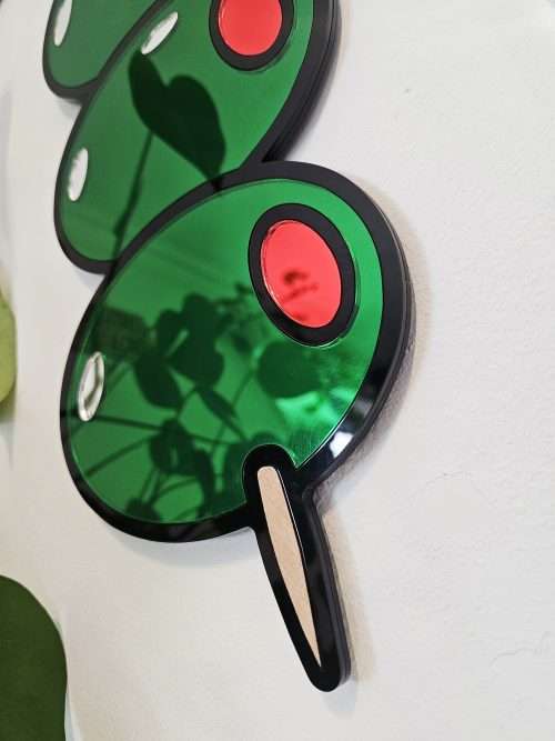 Mirrored wall art in the shape of olives on a cocktail stick.