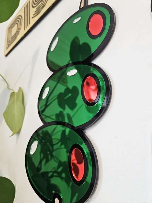 Mirrored wall art in the shape of olives on a cocktail stick.