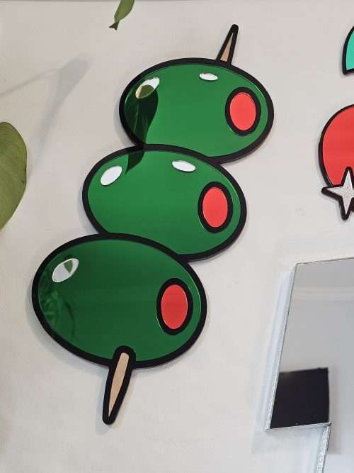 Mirrored wall art in the shape of olives on a cocktail stick.