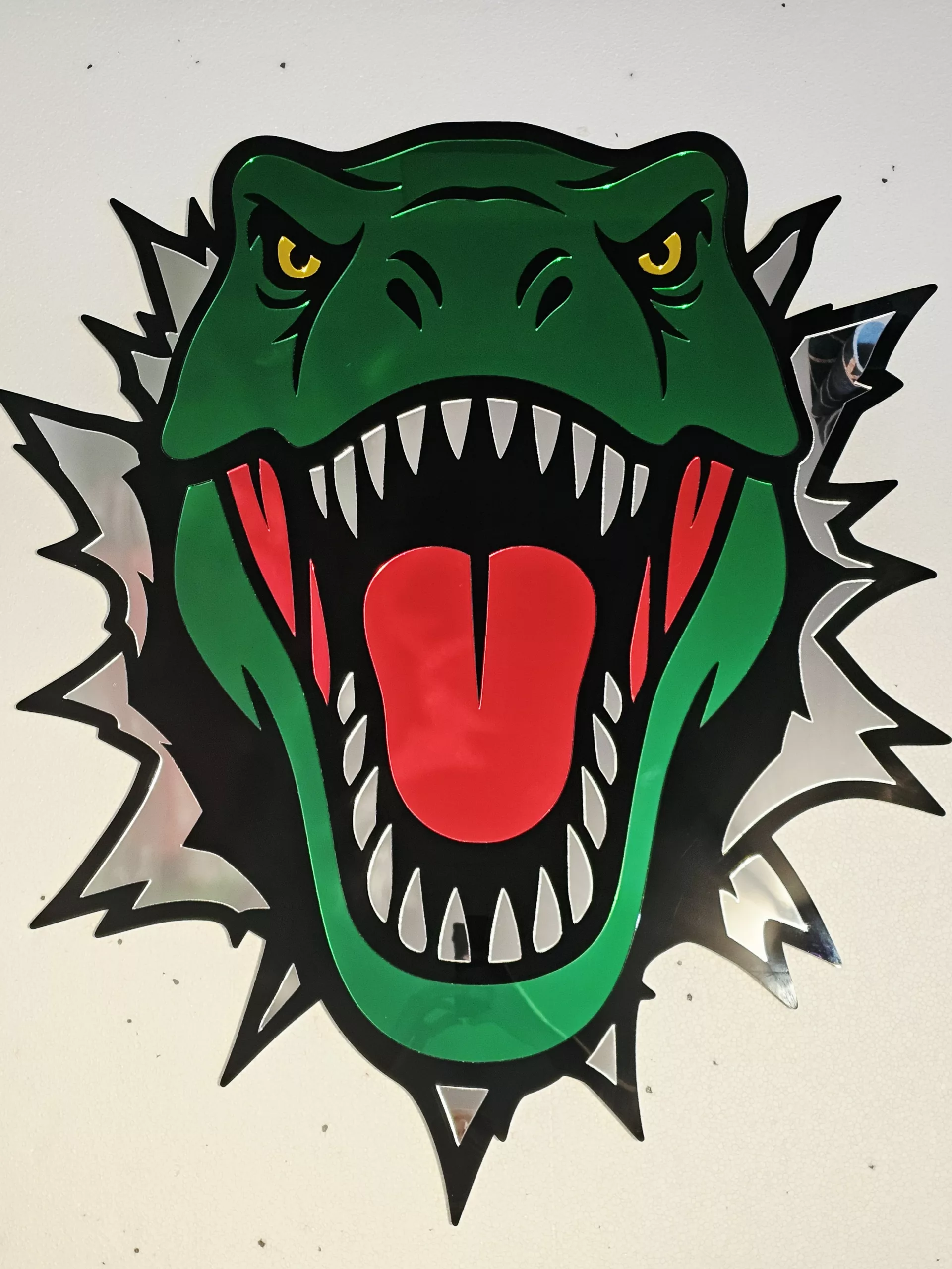 Coloured mirrored acrylic wall art in the shape of a T-Rex dinosaur