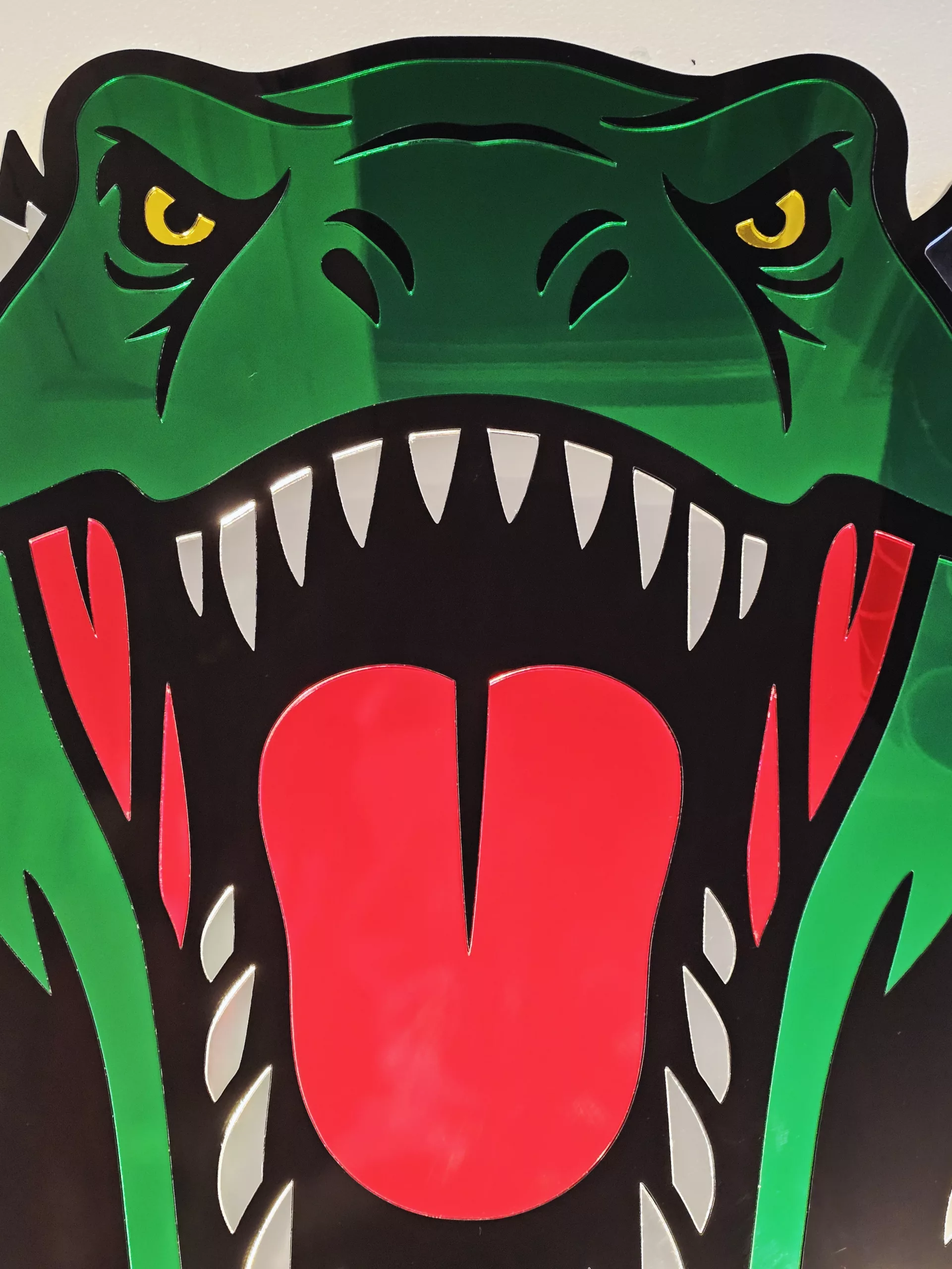 Coloured mirrored acrylic wall art in the shape of a T-Rex dinosaur